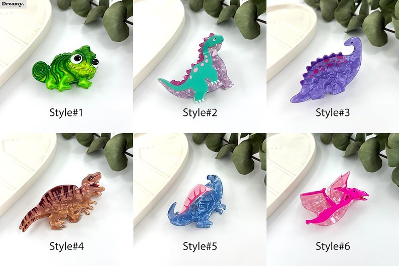 K&ouml;nnte beinhalten: Sechs verschiedene Stile von bunten, glitzernden, plastischen Dinosaurier- und Cham&auml;leon-Broschen. Die Broschen sind alle in verschiedenen Farben und haben eine glitzernde Oberfl&auml;che.