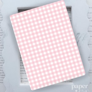 May include: A pink and white gingham patterned card, resting on a white scalloped frame. The card is rectangular and features a classic checkered design. The words "paper & glow" are visible in the bottom right corner.