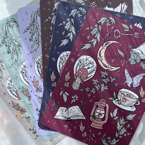 May include: A collection of decorative rectangular art prints with botanical and celestial illustrations. The prints feature a variety of colors, including burgundy, navy, and lavender. Each print showcases detailed drawings of plants, moons, keys, and teacups.