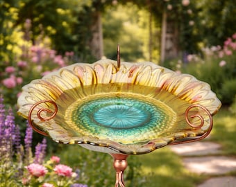 May include: A decorative glass bird bath with a scalloped edge, featuring a vibrant colour palette of yellow, green, and copper. The bird bath is supported by a copper-coloured metal stand with a twisted design, ideal for a garden setting.