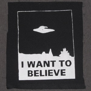 May include: Black and white patch with a UFO and the text "I WANT TO BELIEVE".