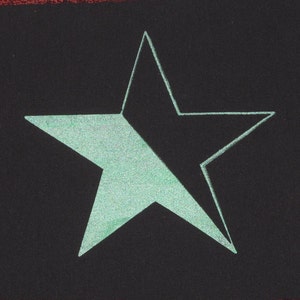 May include: A five-pointed star drawn in white on a black background. The star is filled in with a light green colour.