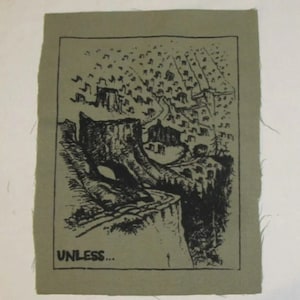 May include: A black and white graphic print on a green fabric patch. The graphic depicts a stylised landscape with a large tree trunk and the words "UNLESS..." at the bottom.