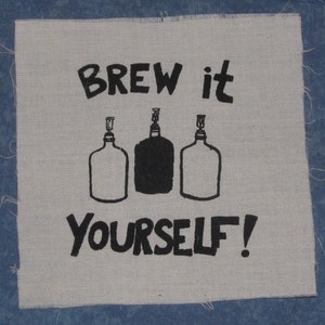 May include: A white fabric patch with black text that reads "Brew it yourself!" and three black and white illustrations of bottles.