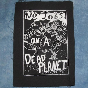 May include: Black and white iron-on patch with the text "No Jobs On A Dead Planet". The patch features a stylised illustration of a factory and a ship.