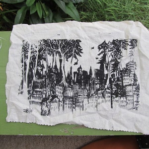 May include: Black and white print on fabric depicting a cityscape with trees in the foreground. The print is on a white background and the cityscape is made up of buildings and trees.