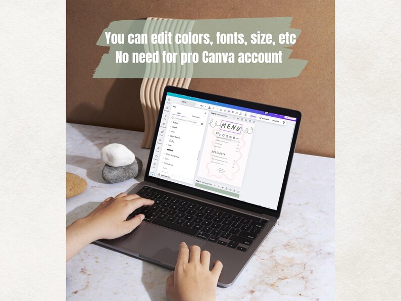 May include: A laptop displaying a menu template with the text "MENU" and "You can edit colors, fonts, size, etc. No need for pro Canva account." The screen shows a menu design with pink accents. Hands are typing on the laptop keyboard.