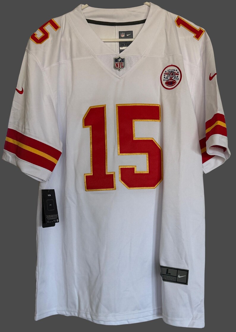 K&ouml;nnte beinhalten: Wei&szlig;es Football-Trikot mit roten und goldenen Akzenten. Die Nummer 15 ist prominent auf der Vorderseite und den Schultern zu sehen. Das Trikot hat das NFL-Logo und einen Nike-Swoosh.