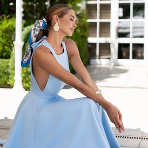 Elegante blauwe midi-cocktailjurk met halterhalslijn en vlinderdas met open achterkant van premium crêpe, perfect voor bruiloftsgast of feest