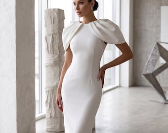 May include: A floor-length white dress featuring a round neckline and structured, pleated cap sleeves. The garment has a fitted bodice with vertical seam detailing that extends down the length of the skirt, creating a streamlined silhouette.
