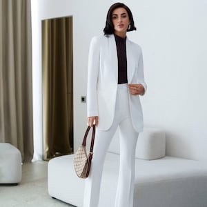 Elegant white women&#39;s suit with lined blazer and flared trousers, classic tailored set for formal events, business or evening looks