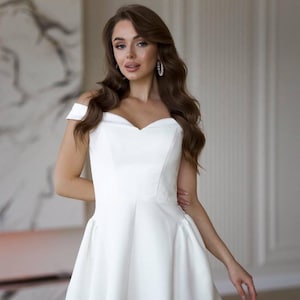 Elegant off shoulder milk white mini dress with built in corset and flared skirt in premium crepe and satin for cocktail or bridal look
