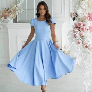 Sophisticated sky blue midi dress with gentle lantern sleeves, defined waist and flowing flare skirt for graceful elegance