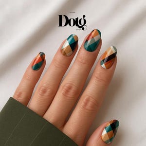 May include: A hand with manicured nails featuring a plaid design in shades of green, orange, brown, and black. The nails are oval-shaped and have a glossy finish. The image includes the text "Dotg Studio".