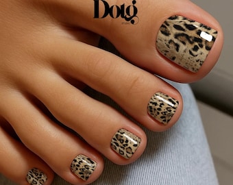 May include: A foot with leopard print nail art. The toenails are painted with a tan and black animal print design. The image includes the text "Dotg Studio".