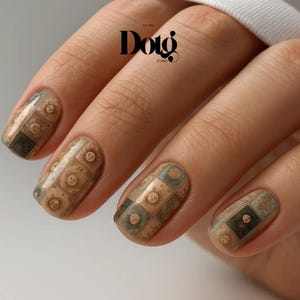 May include: Close-up of manicured nails with a vintage-style design. The nails feature a repeating pattern of squares with sun-like motifs in shades of brown, green, and beige. The logo "Dotg Studio" is visible in the background.