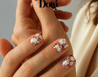 May include: Short, rounded fingernails featuring a vibrant orange base color decorated with a repeating pattern of white ghosts and small black bats. The nail art design covers the entire surface of each nail, creating a festive, seasonal look.