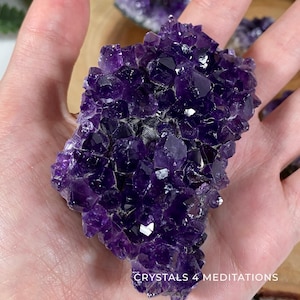 May include: A large amethyst cluster with deep purple crystals. The cluster is about the size of a person's hand and has a rough, natural texture.