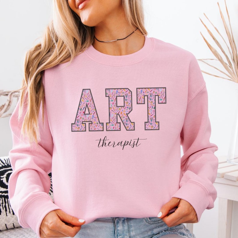 pink gildan sweatshirt with varsity letters with art supplies print in lettering art therapist sweatshirt gift for art therapist