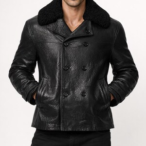 May include: A black leather jacket with a textured finish. The jacket features a double-breasted design with four buttons and a black, fuzzy collar. It has two front pockets and a classic, tailored fit.