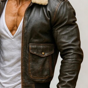 Puede incluir: Chaqueta bomber de cuero marr&oacute;n con cuello de borrego color crema. La chaqueta tiene un bolsillo delantero con bot&oacute;n y dobladillo acanalado. La chaqueta se lleva sobre una camiseta blanca con cuello en V. Estilo cl&aacute;sico.