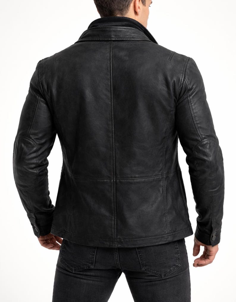 May include: A black leather jacket with a textured finish. The jacket features a notched collar, buttoned cuffs, and a tailored fit. The back view showcases the jacket's seams and design details, offering a classic and stylish look.