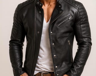 Puede incluir: Chaqueta de cuero negra con diseño acolchado en hombros y mangas. La chaqueta tiene cierre de cremallera, múltiples bolsillos y cuello con botones a presión. Se ve un cinturón marrón y una camisa blanca.
