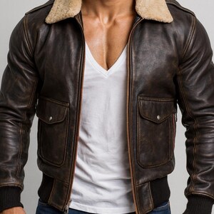 Puede incluir: Chaqueta bomber de cuero marr&oacute;n con cuello de borrego beige. La chaqueta tiene dos bolsillos delanteros, dobladillo y pu&ntilde;os acanalados. Se usa sobre una camiseta blanca con cuello en V y vaqueros azules.