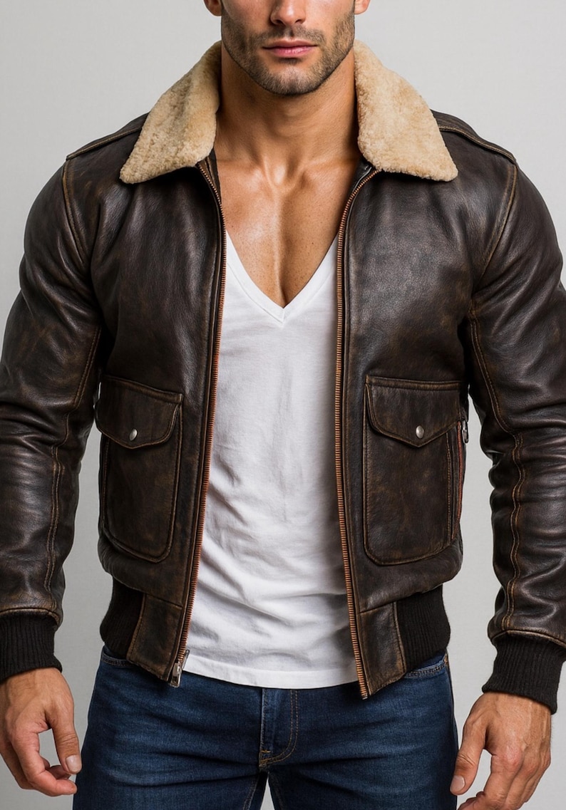 Puede incluir: Chaqueta bomber de cuero marr&oacute;n con cuello de borrego beige. La chaqueta tiene dos bolsillos delanteros, dobladillo y pu&ntilde;os acanalados. Se usa sobre una camiseta blanca con cuello en V y vaqueros azules.