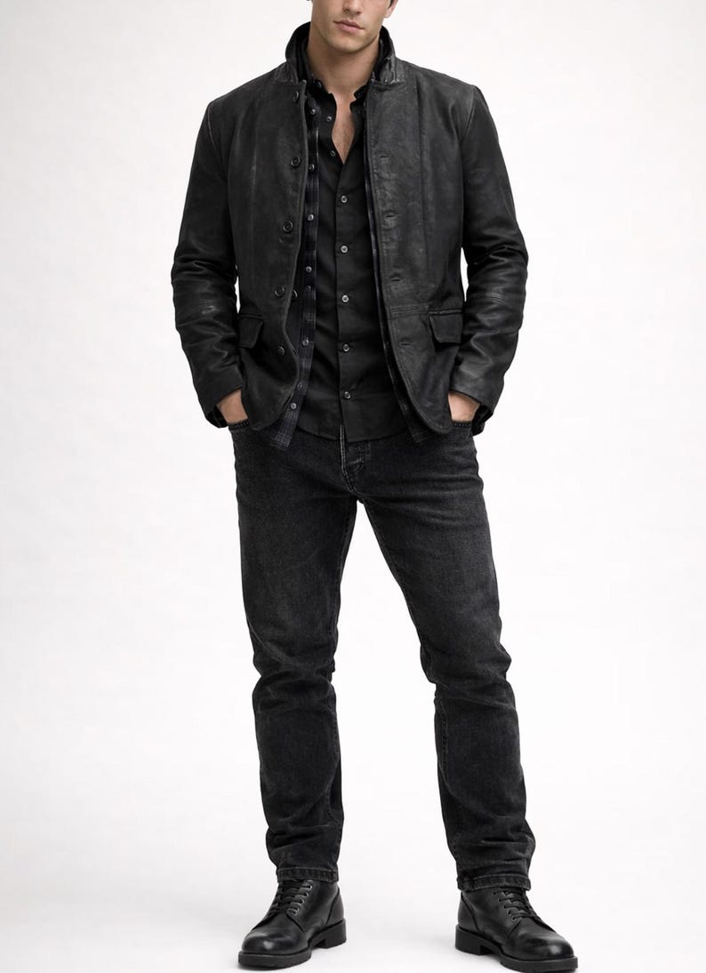 May include: A black leather jacket with a button-up front, paired with a black button-down shirt and dark wash jeans. The outfit is completed with black leather boots. The overall style is a classic, monochromatic look.