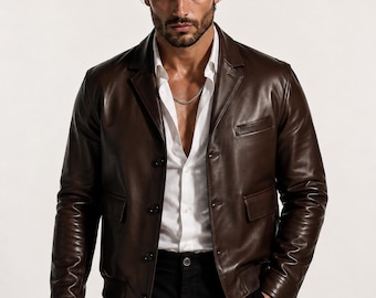 May include: A dark brown leather jacket featuring a notched lapel, a button-front closure, and two front flap pockets. The jacket is worn over a crisp white button-down shirt and paired with black trousers, creating a structured and classic look.