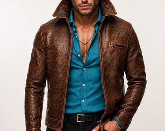 May include: A brown textured leather jacket with a high collar and front zipper, worn over a bright teal button-down shirt and black trousers with a black belt. The jacket features a zippered chest pocket and two side pockets with leather pulls.