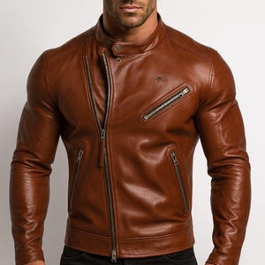 Peut inclure: Veste en cuir marron avec fermeture éclair asymétrique. Elle possède un col montant et plusieurs poches zippées. Le design de la veste est ajusté, et le cuir a une texture lisse et une couleur marron chaude et riche.