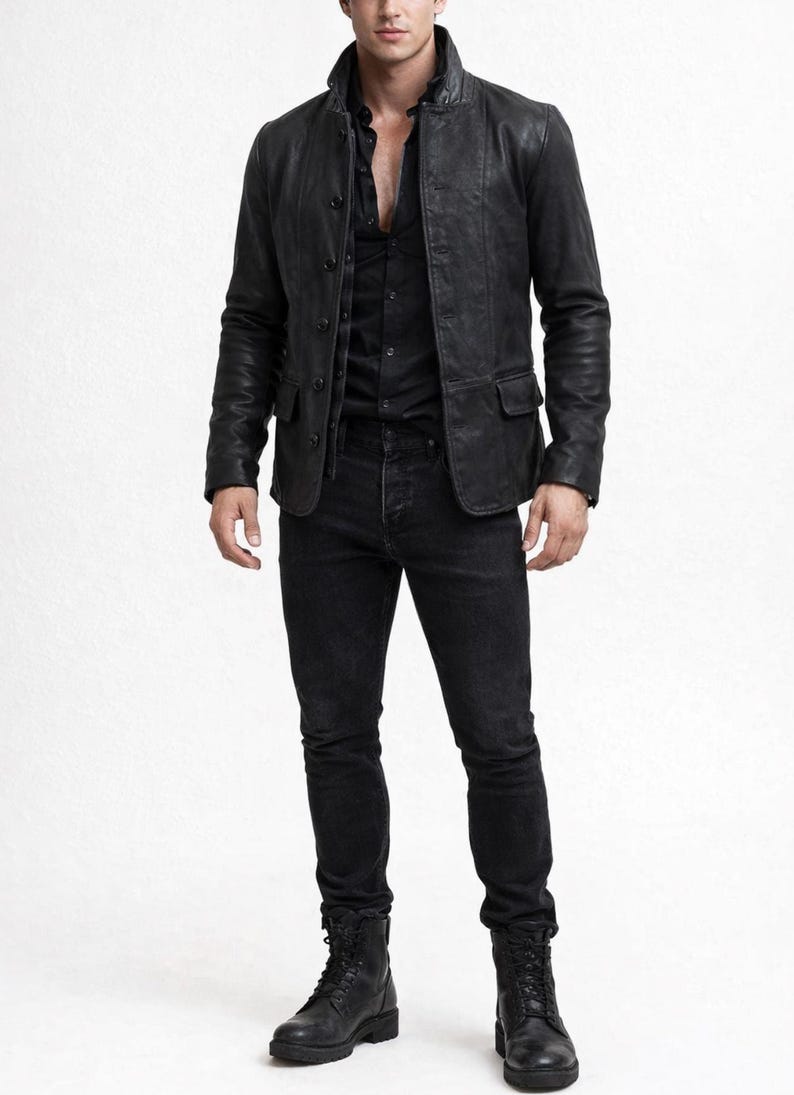May include: A black leather jacket with a button-up front, paired with a black button-down shirt and black jeans. The outfit is completed with black lace-up boots. The clothing is all black, creating a monochromatic look.