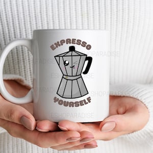 May include: White ceramic coffee mug with a black handle featuring a cartoon illustration of a stovetop espresso maker. The text "EXPRESSO YOURSELF" is printed above and below the illustration in a brown font.