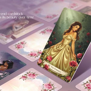 May include: A collection of tarot cards featuring illustrations of women in elegant gowns and floral accents. The central card displays "III. The Empress" with a woman in a gold dress. The text "Durable, high-end cardstock that maintains its beauty over time" is visible.