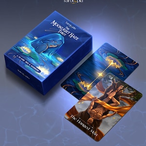 May include: A blue tarot card box and cards with the text "Tarotopia" and "The Moonlight Haze Tarot". The box features an illustration of a woman in water. One card shows "The Hanged Man".