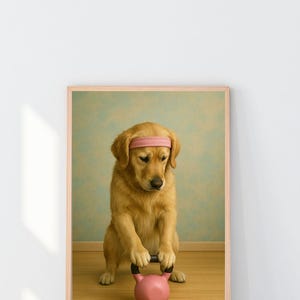 May include: A framed print showing a golden retriever wearing a pink headband, lifting a pink kettlebell. The dog is on a wooden floor, with a light blue and green wall behind. The print is in a light brown frame.