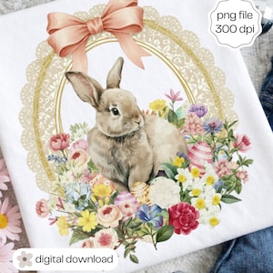Puede incluir: Camiseta blanca con una ilustración de acuarela de un conejito rodeado de flores y huevos de Pascua. Un lazo color melocotón se encuentra sobre un marco de encaje dorado. El texto "png file 300 dpi" es visible.