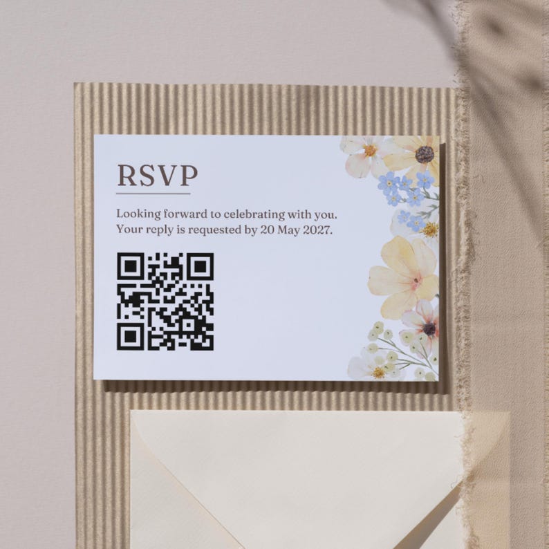 May include: RSVP card with floral accents. The card reads "Looking forward to celebrating with you. Your reply is requested by 20 May 2027." A QR code is present. The card is on a textured background.