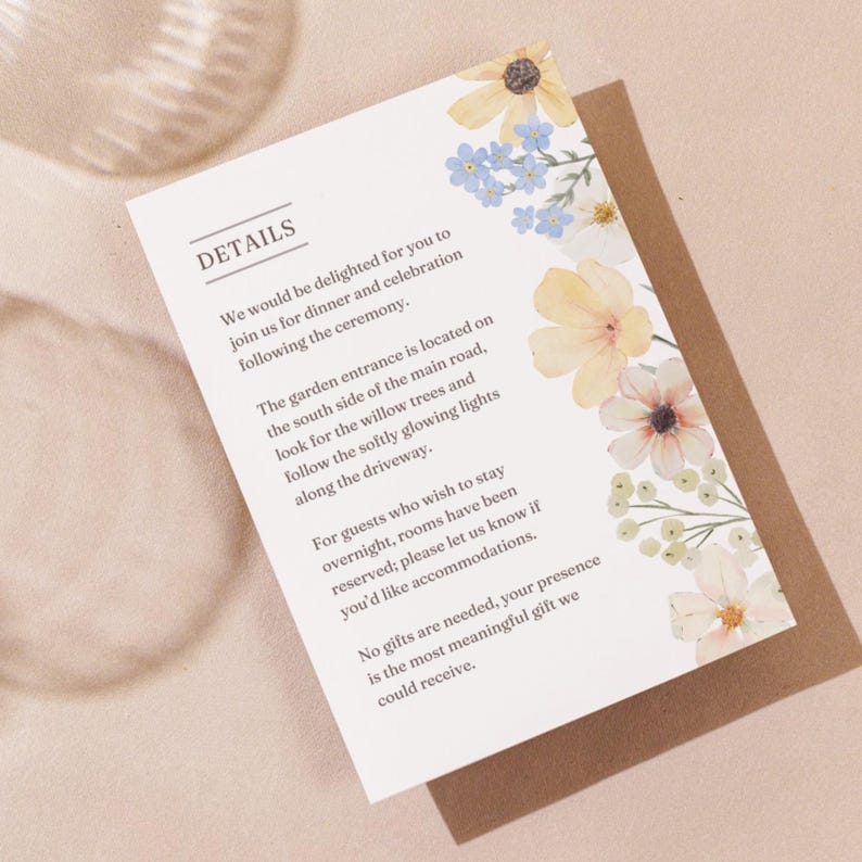 May include: A wedding details card with floral watercolor accents. The card features text about the ceremony and reception details. The card is decorated with yellow, white, and blue flowers. The card is on a brown background.