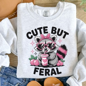 Lindo pero salvaje PNG, Mapache divertido PNG, Diseño de mapache con lazo, Diseño de sublimación PNG, Diseño animal de moda PNG, Diseño de transferencia DTF, Divertido.