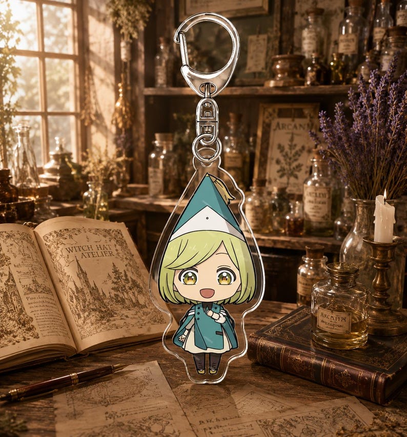 May include: A clear acrylic keychain featuring a stylized anime character with short blonde hair, large golden eyes, and a wide smile. The character wears a teal pointed hat and a matching teal cape over a white outfit, attached to a silver metal clasp.