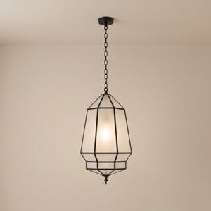 May include: A geometric pendant light fixture with a black metal frame and frosted glass panels. The light hangs from a chain and has a decorative finial at the bottom. The fixture is designed to be mounted on a ceiling.