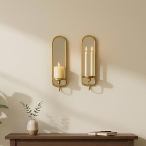 Brass wall candle holders with arched mirrors, displayed with a lit pillar candle and two lit taper candles