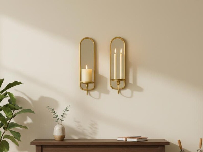Brass wall candle holders with arched mirrors, displayed with a lit pillar candle and two lit taper candles