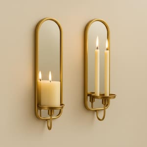 Brass wall candle holders with arched mirrors, displayed with a lit pillar candle and two lit taper candles