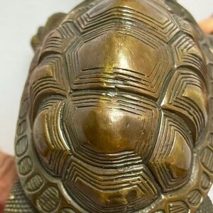 May include: A bronze turtle figurine with a detailed shell pattern. The shell features geometric designs and textured lines, creating a vintage aesthetic. The figurine's color is a mix of bronze and gold.