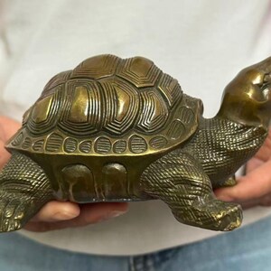 May include: Bronze turtle figurine with detailed shell and textured skin. The turtle's head is raised, and its legs are extended. A decorative item for home decor.