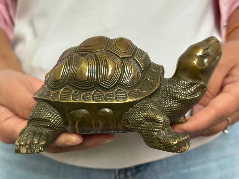May include: Bronze turtle figurine with detailed shell and textured skin. The turtle's head is raised, and its legs are extended. A decorative item for home decor.